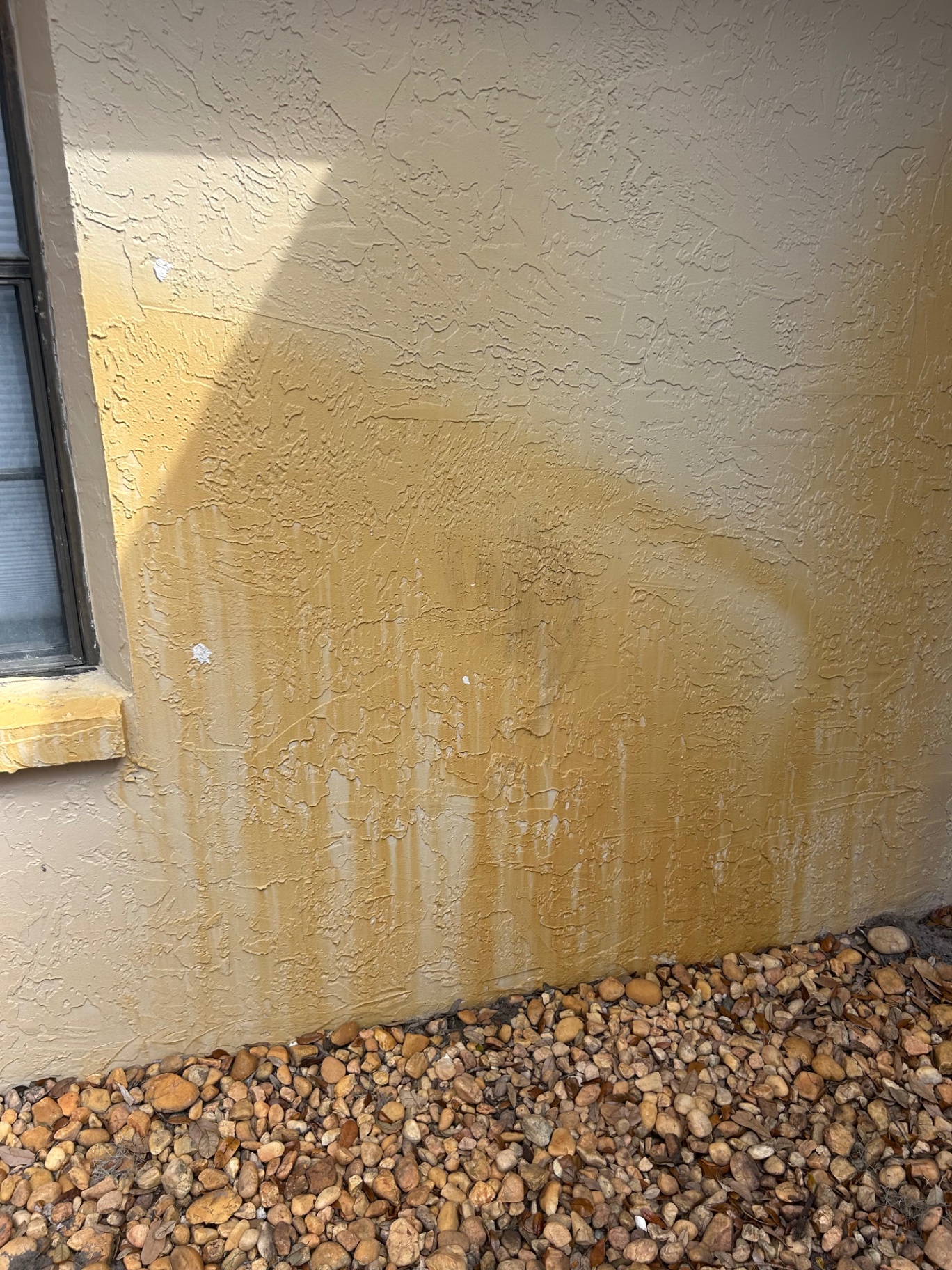 Stained stucco wall before soft washing